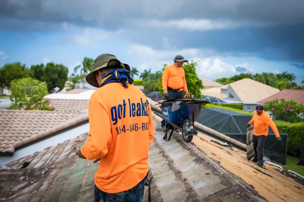 distinctive roofing crew member wearing an orange t-shirt saying "got leaks" on roof repair job