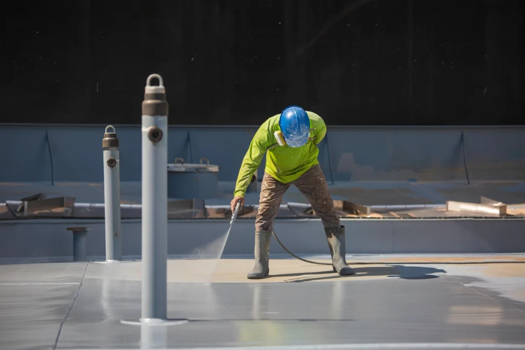 flat roof coatings being sprayed by roofing contractor
